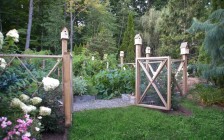 A Cedar Decorative Fence and Birdhouses Surround an Organic Vegetable Garden